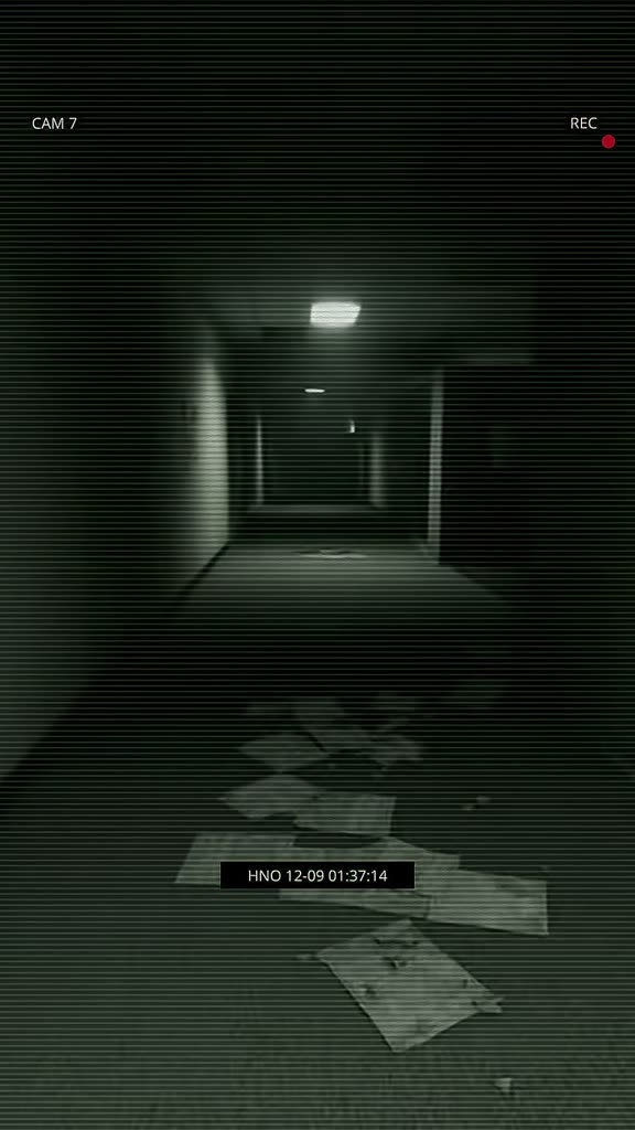 Security-camera footage of an empty office corridor at night